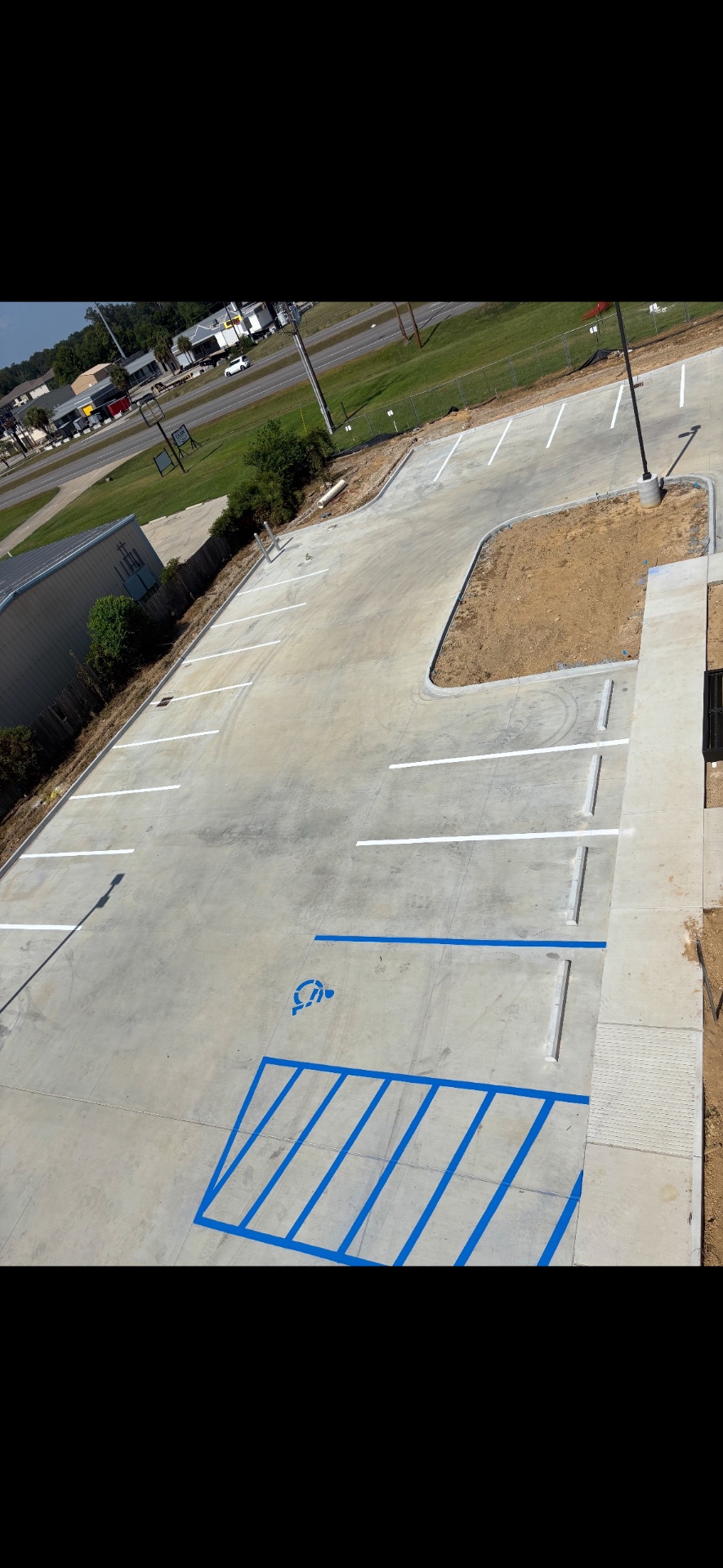 New parking lot with crisp white stalls and blue accessible markings